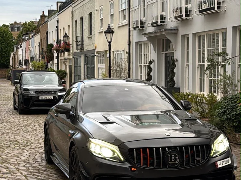 A black Mercedes C63 on a cobbled London mews