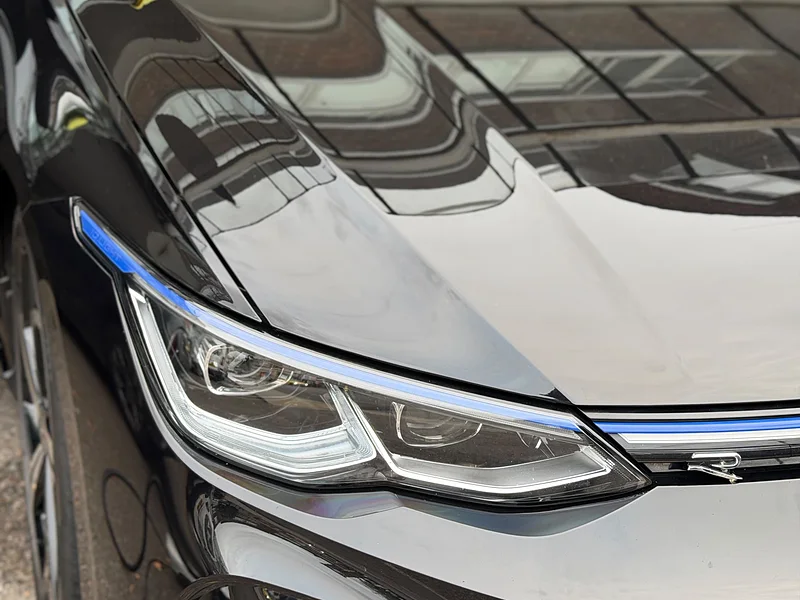 Building reflections in the deep gloss of a black bonnet
