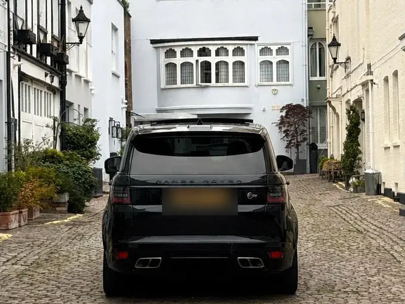 A dechromed Range Rover Sport with tinted rear glass on a London mews