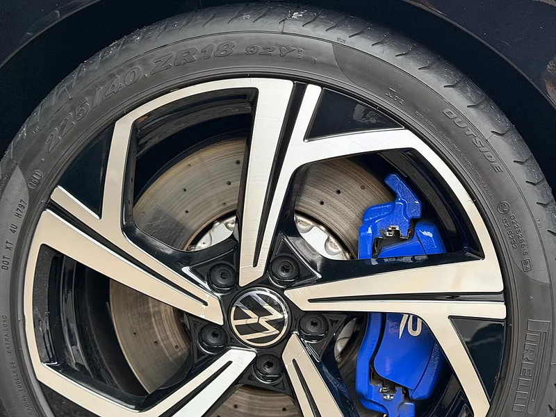 A cleaned Golf R alloy wheel with blue brake calipers behind it